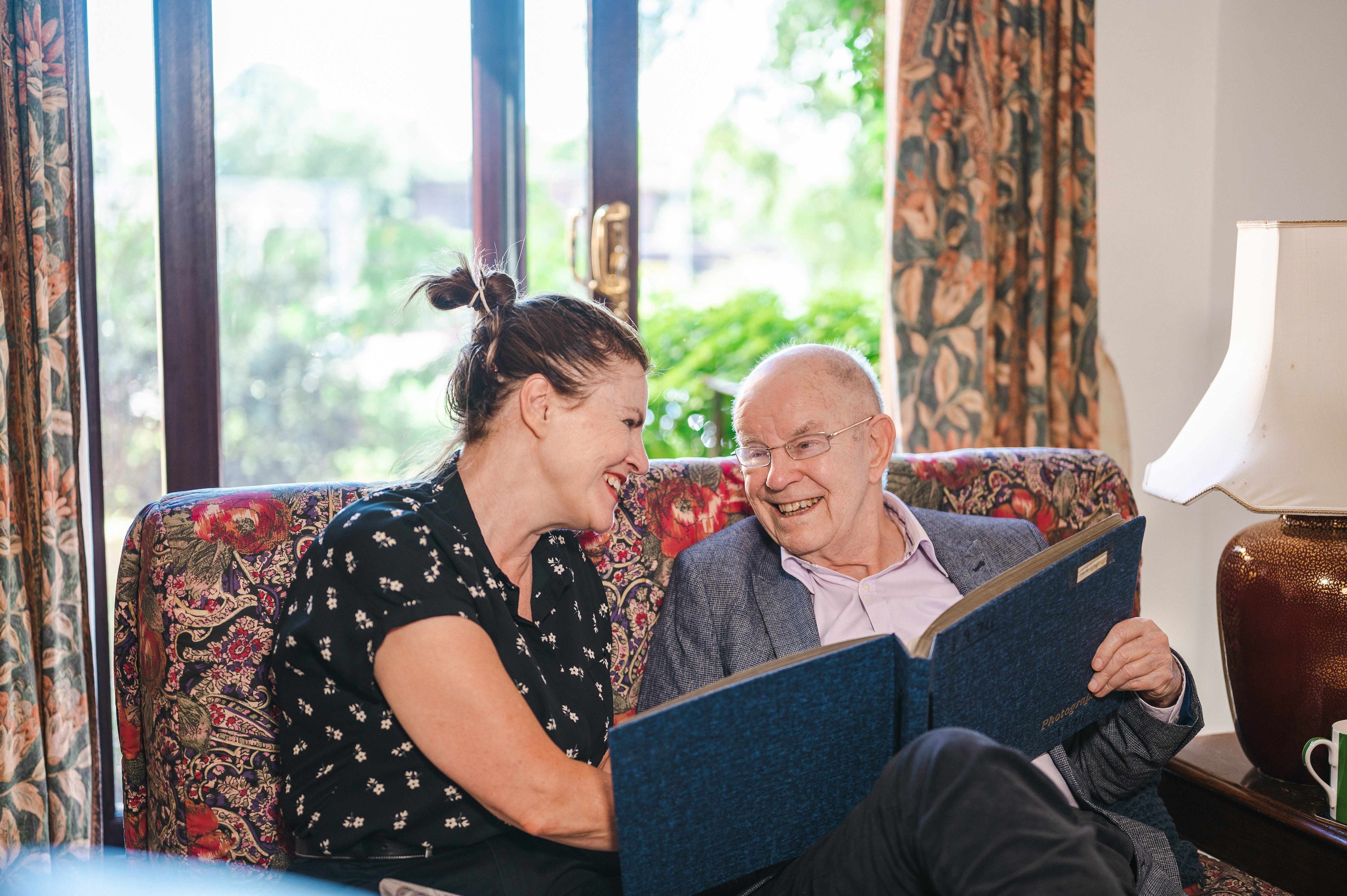 A carer and client looking through a photo album together