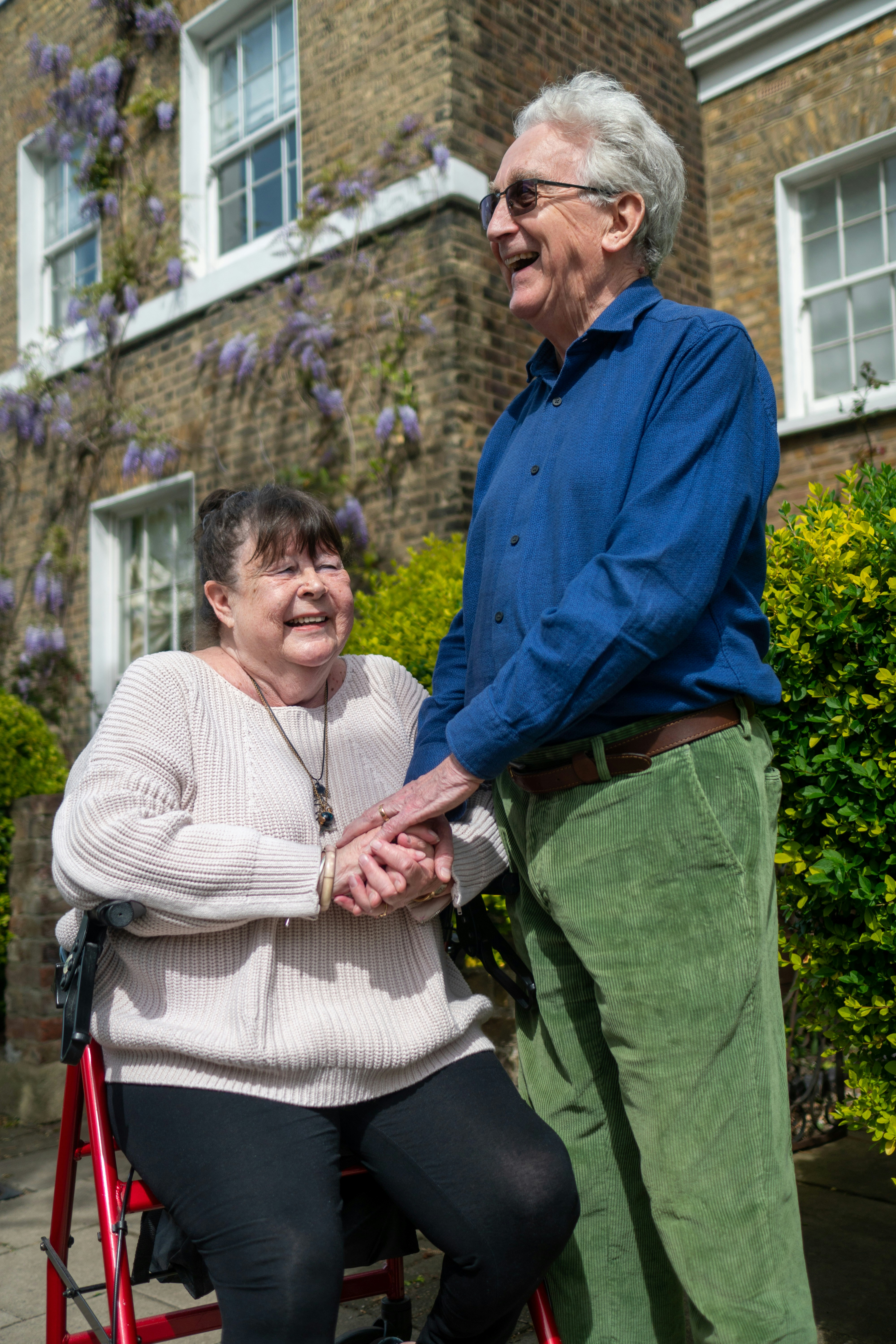 A couple laughing together outside their home